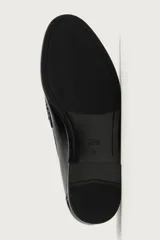 Mocasín de vestir negro de estilo clásico con detalle de antifaz en la parte superior, suela a tono y ligero tacón.