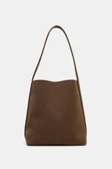 Bolso de hombro tipo saca, de diseño minimalista y estructura flexible. Cuenta con asa de hombro, cierre mediante clip metálico y compartimento interior extraíble con cremallera.