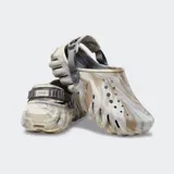 Zuecos Crocs modelo Echo Clog Marbled, con diseño esculpido y moderno, confeccionados con material croslite con efecto marmoleado en tonos beige y gris. Cuenta con aberturas de ventilación, correa ajustable en el talón y suela texturizada.