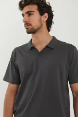 Chomba negra de piqué con cuello clásico y mangas cortas.