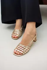 Sandalias de cuero doradas con tiras finas horizontales en el empeine, pulsera con hebilla al tobillo y tacón cuadrado.
