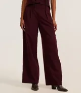 Pantalón pantalona color borgoña de tiro alto y corte palazzo, confeccionado en cupro con pliegues delanteros.