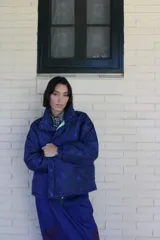 Campera puffer de diseño capitoneado, confeccionada en tela impermeable con estampado multicolor de motivos marinos y cadenas. Presenta cuello alto, cierre frontal con botones a presión y puños elásticos.