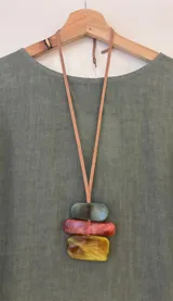 Collar largo con cinta de gamuza regulable color marrón y dije con tres piezas rectangulares de acrílico en tonos verde, naranja y amarillo.