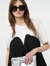 Vestido corto negro, estilo globo o balloon, con escote corazón pronunciado. Se lleva sobre una remera blanca de manga corta.