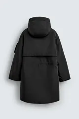 Parka técnica de corte relajado con acabado repelente al agua. Presenta cuello subido con capucha ajustable, cierre frontal con cremallera oculta por solapa con botones y cintura ajustable con cordón. Incluye múltiples bolsillos frontales con solapa, un bolsillo con cremallera en la manga y puños con interior en rib. El diseño cuenta con interior acolchado y aberturas laterales con cremallera en el bajo.