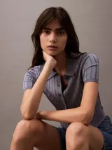 Top tipo chomba cropped de punto acanalado color celeste con cuello polo, cierre frontal con botones y mangas cortas.