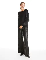 Buzo de tejido negro con mangas largas de microtul transparente, decoradas con bordados de lentejuelas y flecos brillantes. Presenta un diseño elegante con cuello redondo.