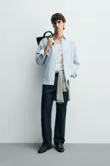 Camisa regular fit de color celeste, confeccionada en tejido con mezcla de algodón y seda, con cuello solapa, manga larga con puño abotonado y cierre frontal de botonadura.