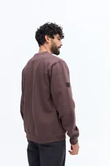 Buzo de algodón azul marino, corte regular, con cuello redondo. Presenta un bordado de flores y texto en el pecho.