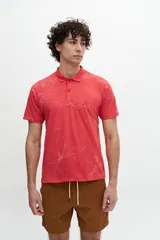 Chomba color coral con estampado de hojas blancas, cuello clásico con cartera de dos botones y logo bordado en el pecho.