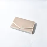 Joyero tipo sobre color beige con borde blanco.