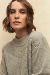 Polera de cuello alto tejida con diseño de textura en chevron y puños elastizados.