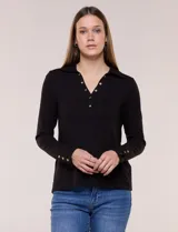 Remera negra de tejido de punto acanalado, de silueta al cuerpo, con cuello polo, abertura frontal en V con botones dorados, mangas largas ajustadas con puños abotonados y ruedo recto.