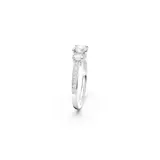 Anillo de compromiso o de cóctel con tres piedras centrales redondas engastadas en un engaste de tres puntas, flanqueadas por pavé de cristales más pequeños a lo largo de la banda.