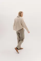 Pantalón sastrero de tiro medio, color gris oscuro con rayas verticales finas. Presenta pinzas delanteras, bolsillos delanteros con pin bordado y bolsillos traseros tipo vivo.