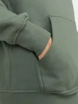 Canguro verde oliva de manga larga con capucha, corte relajado y bolsillo tipo canguro. Estampado con el texto "Originals Studio" en el pecho.