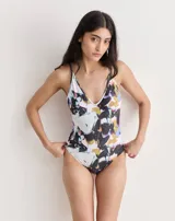 Malla entera celeste con estampado de flores negras y terminaciones en color naranja.