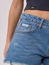 Short de jean azul con roturas y terminaciones desflecadas.