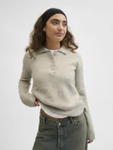 Sweater de punto color beige, con cuello polo y cierre frontal de tres botones, mangas largas con puños acanalados y diseño clásico.