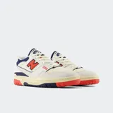 Championes urbanos New Balance modelo 550, color blanco con detalles en azul y rojo, confeccionados en cuero y malla, con logo "N" característico en los laterales.