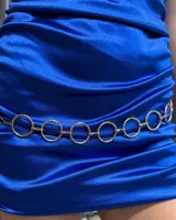 Cinturón de cadena compuesto por eslabones circulares metálicos de color dorado, con diseño minimalista y cierre ajustable.