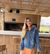 Campera de jean azul con capucha y detalles de bordado artesanal multicolor en la capucha, el pecho, los bolsillos y las mangas. Cuenta con cierre frontal de botones, bolsillos delanteros y diseño cómodo.