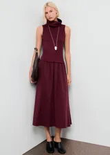 Vestido midi de diseño combinado en color bordó. Presenta un cuerpo sin mangas con cuello embudo y una falda de corte recto con caída fluida.