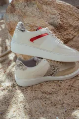 Zapatillas bajas de cuero color beige con detalles en animal print y suela blanca.