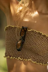 Bombacha de bikini tipo colaless con cintura ancha confeccionada en punto smock. Presenta un diseño en color marrón con bordes amarillos fruncidos.