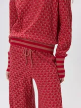 Sweater de tejido de punto jacquard con diseño geométrico, cuello redondo y puños acanalados en contraste de color verde y beige.