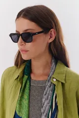 Lentes de sol con marco negro y patillas color carey.