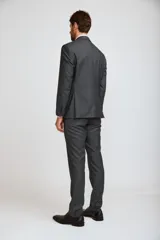 Ambo de hombre compuesto por saco de dos botones y pantalón de vestir a juego, en color gris oscuro. Incluye camisa rosa y corbata estampada en tonos rosados.