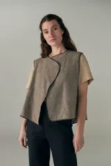 Chaleco corto de lana fina sin teñir, con diseño de solapa cruzada y terminaciones envivadas. Es una prenda reversible, liviana y versátil, ideal para uso diario.