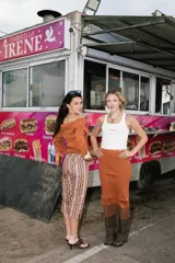 Saco tejido de punto color naranja con efecto bicolor, escote off-shoulder y cierre frontal bidireccional.