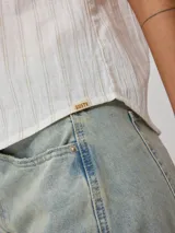 Musculosa color crudo con rayas verticales color óxido.