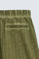 Bermuda de algodón color verde oliva, con corte relajado y textura acanalada vertical. Presenta cintura elástica con cordón interior y bolsillos laterales y trasero.