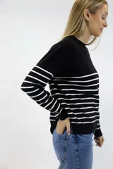 Buzo de tejido fino con diseño de rayas horizontales en contraste. Presenta cuello redondo, mangas largas y terminaciones acanaladas en cuello, puños y cintura.