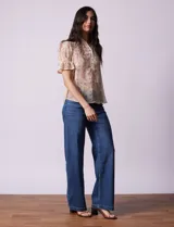 Blusa de gasa estampada marca Alex & Lili. Tiene cuello a la base con solapa y escote en V, mangas cortas con punto smock y terminación amplia. Delantera, solapa y mangas con aplique en crochet.