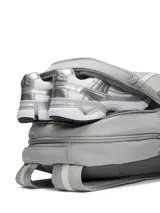 Mochila Under Armour modelo Hustle 6.0 de 29 litros, color gris. Cuenta con tecnología Storm resistente al agua, funda acolchada para portátil de hasta 16 pulgadas, bolsillos laterales de malla y diseño ergonómico.