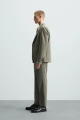 Blazer de corte regular fit confeccionado en tejido con lana, con cuello de solapas de muesca, cierre frontal de un botón, bolsillos de solapa en la cadera y bolsillo de vivo en el pecho.