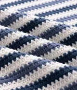 Polo de punto de manga corta para hombre, con cuello estilo cubano (sin botones) y patrón de rayas verticales en tonos azul marino, blanco y gris claro.