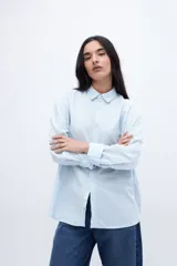 Camisa celeste de algodón con cuello solapa clásico, manga larga con puños abotonados, calce relaxed y bolsillo cuadrado en el pecho.