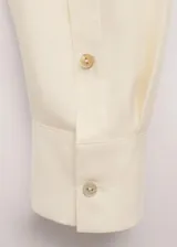Camisa de seda 100% en color amarillo claro, con cuello clásico, cierre frontal oculto con botones y mangas largas.