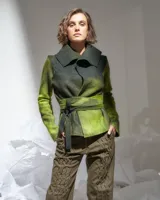 Chaqueta de lana merino afieltrada color verde camuflaje, de corte desestructurado, con cuello alto y tiras para atar en la cintura o cruzar en el cuello.