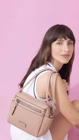 Bandolera color beige de símil cuero, con cierre principal, bolsillos interiores, bolsillo frontal y posterior con cierres, y bolsillos laterales. Incluye correa extensible.