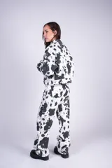 Campera corta de denim con estampado tipo animal print de vaca en color blanco y negro, con cuello camisero, cierre frontal de botones metálicos y bolsillos con solapa en el pecho.