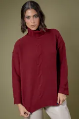 Buzo de cuello alto tejido en lana, con diseño de ochos en el centro y mangas largas con hombros caídos.