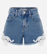 Short de jean tiro medio con encaje floral blanco aplastado en los laterales y dobladillo deshilachado. Cuenta con bolsillos delanteros y traseros, pasacintos y cierre frontal con botón y cremallera.