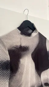 Minivestido ajustado con cuello alto y mangas largas acampanadas, con estampado abstracto en blanco y negro.